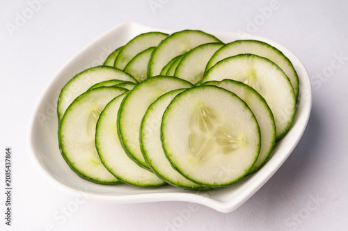 Thinly sliced cucumber in a white bowl