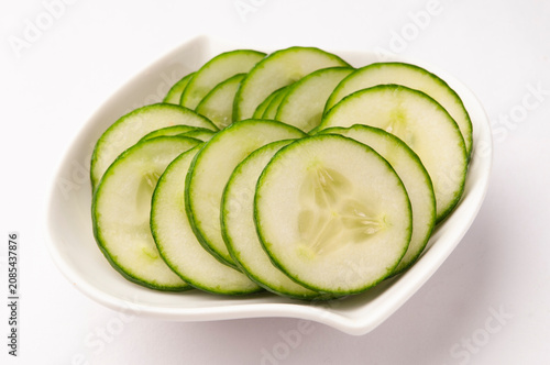Thinly sliced cucumber in a white bowl