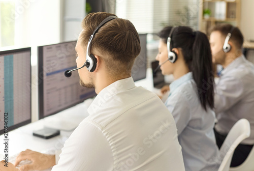 Fotografie Callcenter operators with headsets provide customer support