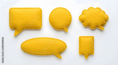 Yellow Felt Speech Bubbles: A collection of vibrant yellow felt speech bubbles in various shapes, arranged playfully, symbolizing communication and dialogue.
