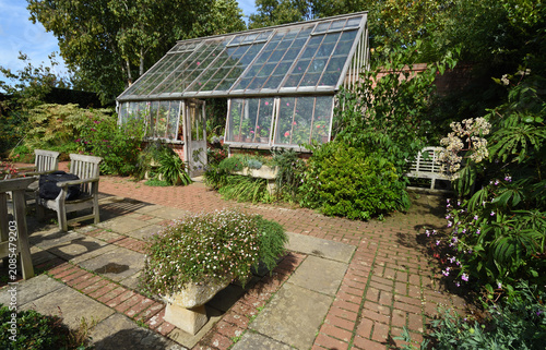 Garden with Greenhouse chairs and table, stone platers  and flowers