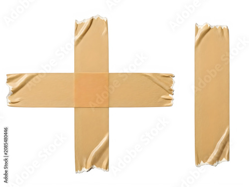 Strips of brown masking tape arranged in a cross shape and a single piece for design projects