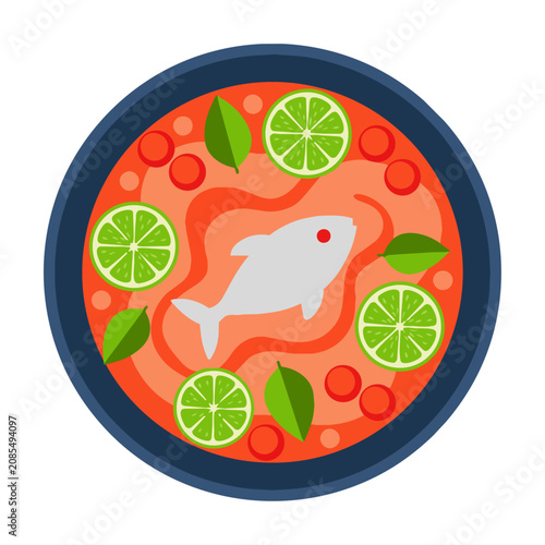 Top view of a bowl of spicy Thai soup with fish, lime slices, and fresh herbs isolated on white background. Healthy food concept