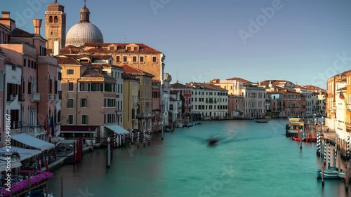 Venice Grand Canal time lapse of moving shadows and blurred boat traffic near San Geremia church at golden hour sunset, historic Italian cityscape