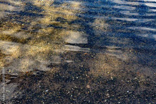 Fotografi Clear water ripples over sandy and pebbly river bed