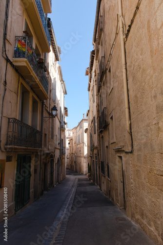 Ruelle médiévale étroite et pittoresque avec balcons en fer forgé sous le soleil du Midi, Montpellier, France.