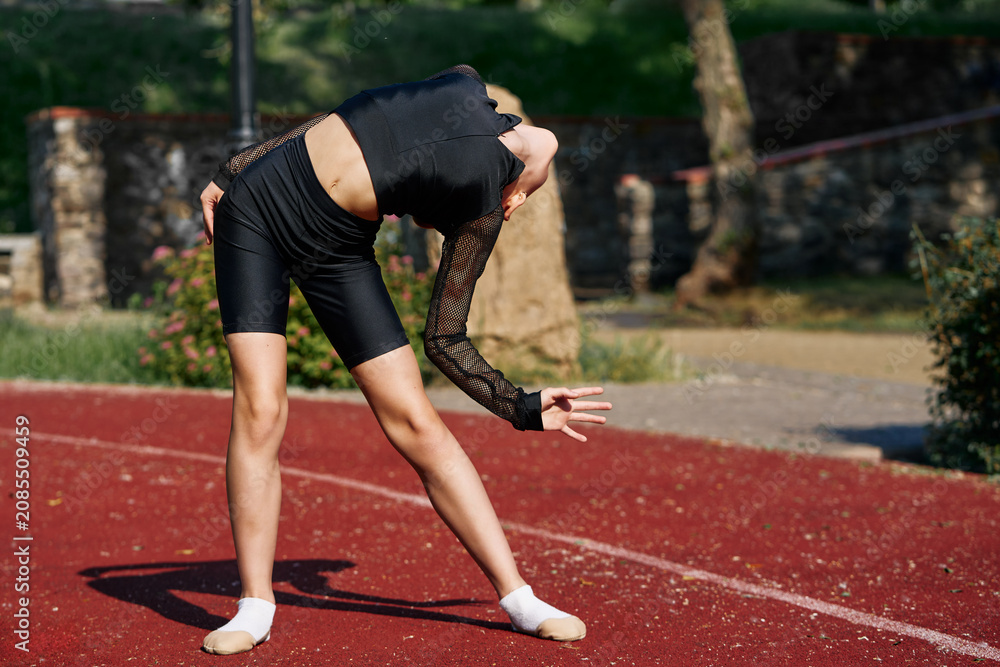 Fototapeta premium Young Athlete Posing Gracefully During an Outdoor Gymnastics Practice