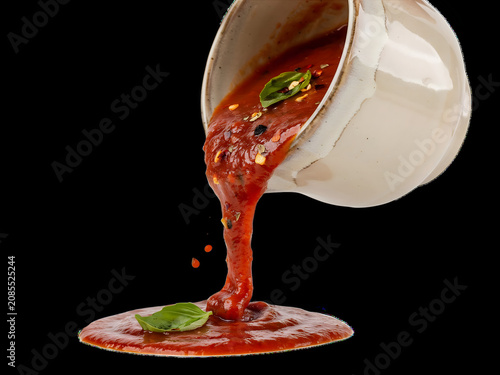 Close-up of Tomato Sauce Being Poured from a White Bowl