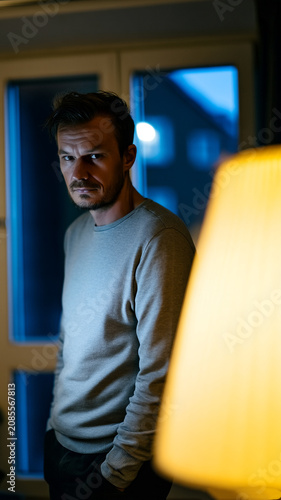 Suspicious Man Standing by Window in Apartment at Night