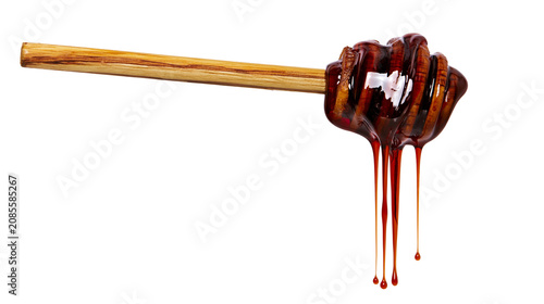 Foto Wooden honey dipper with dripping dark amber honey