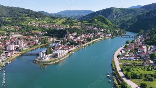 Visegrad, Bosnia and Herzegovina – May 30, 2026: Elevated drone panorama showing Andricgrad, the Drina River and surrounding mountain landscape