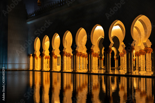 Konstfotografi Horizontal wide shot of the illuminated Moorish arches and ornate columns of a Mosque at night