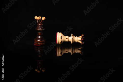 Принти на полотні Dark chess queen standing over fallen white queen in black background
