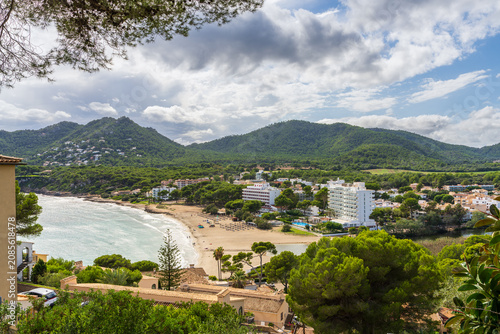Elevated view of charming seaside resort of Canyamel, Mallorca. Mediterranean coastline, turquoise sea, scenic mountain landscape, summer vacation and travel destination concept.