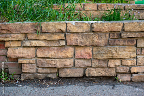 Decorative natural stone retaining wall with green grass
