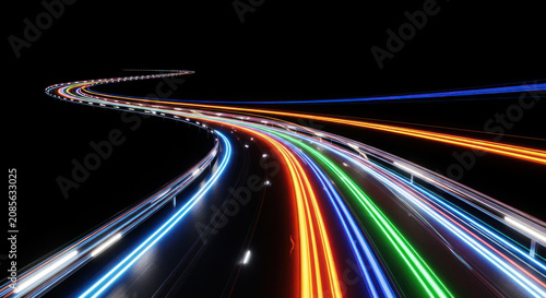 A long, curving highway stretches into the darkness, illuminated by streaks of vibrant light trails from speeding vehicles.
