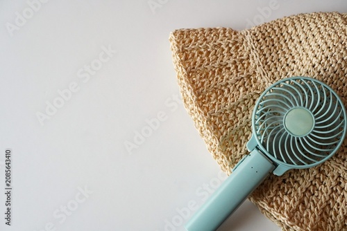 Handheld Fan and Straw Hat on White Background, Summer Heat Protection Concept