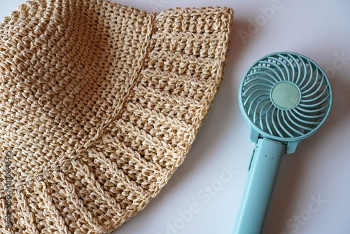 Handheld Fan and Straw Hat on White Background, Summer Heat Protection Concept