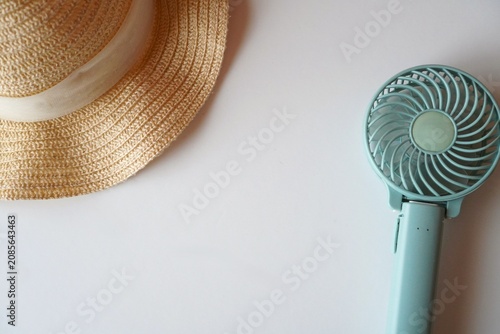 Handheld Fan and Straw Hat on White Background, Summer Heat Protection Concept