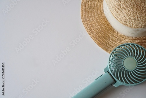 Handheld Fan and Straw Hat on White Background, Summer Heat Protection Concept