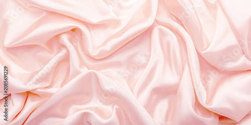 Abstract elegant blush pink satin silk fabric texture with glossy flowing folds, soft pastel drapery and luxury background