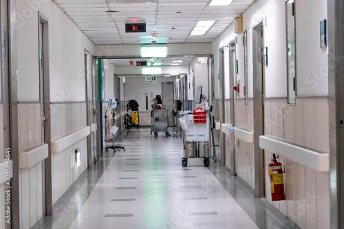 Foto A nurse pushes a medical trolley through a bright hospital corridor, transporting medications and clinical supplies for patient care