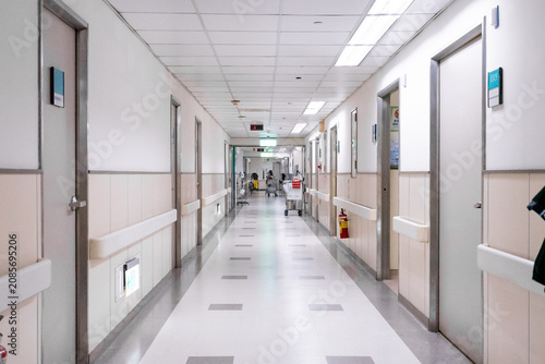 Foto A nurse pushes a medical trolley through a bright hospital corridor, transporting medications and clinical supplies for patient care