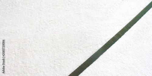 Obraz na plátne Close up top view of white terry cloth towel texture with a diagonal green stripe border