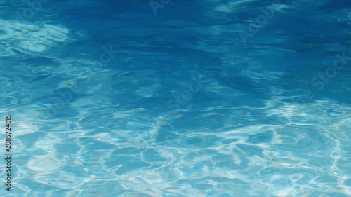 Ripples on the water of the pool, transparent, sparkling, inviting surface of the water in motion, view from above. slow motion and looped video.