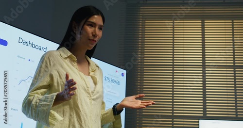 A female leader discusses financial data on a monitor while the team aligns on strategic business decisions.