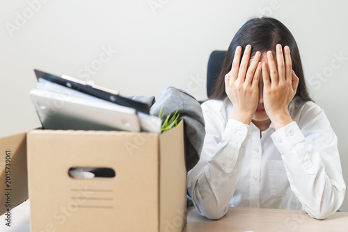 Obraz na plátně Unemployed, quite job, desperate asian young businesswoman resigning from company packing belongings, stuff in box cardboard, layoff or leaving, changing work