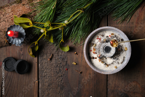 Frankincense and dried herbs burning on glowing charcoal - placing incense with a spoon, copy space