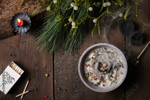 Frankincense, resins and dried herbs burning on glowing charcoal with dark background