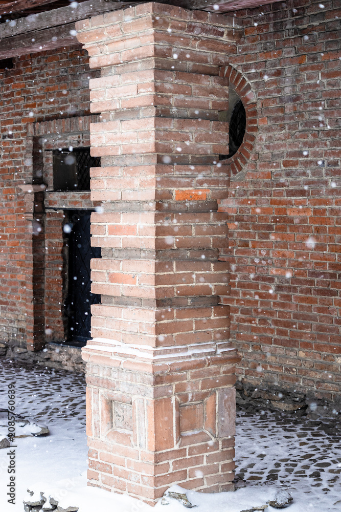 Obraz premium brick column of old building during snowfall