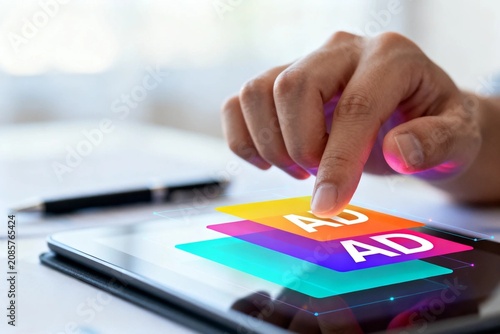 Hand tapping colorful AD icon on tablet
