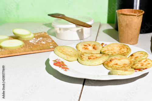 Process of frying zucchini on a wooden board in the kitchen. Ukrainian cuisine