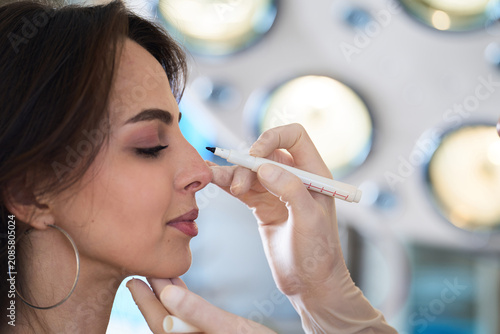 Foto Plastic surgeon performs preoperative nose marking on female patient to plan aesthetic beauty enhancement and septum correction