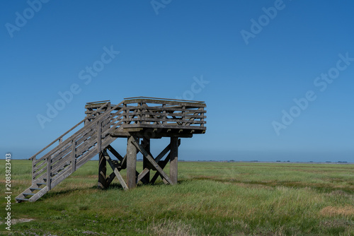 Foto Wooden observation tower on a grassy marshland at Hallig langeneß
