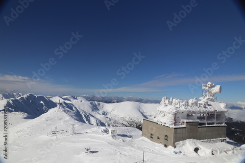 Ice-covered weather station building on mountain summit