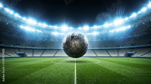 Surreal concept of a moon floating above a soccer stadium field under bright stadium lights