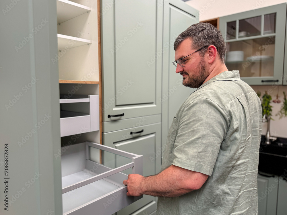 Fototapeta premium Customer choosing kitchen cabinets in a modern kitchen showroom