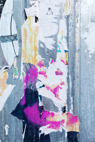 Natural collage of Torn paper posters on a weathered metal surface