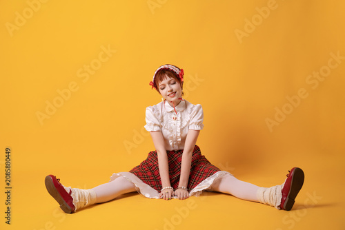 Obraz na plátně A young girl in a studio on a yellow background