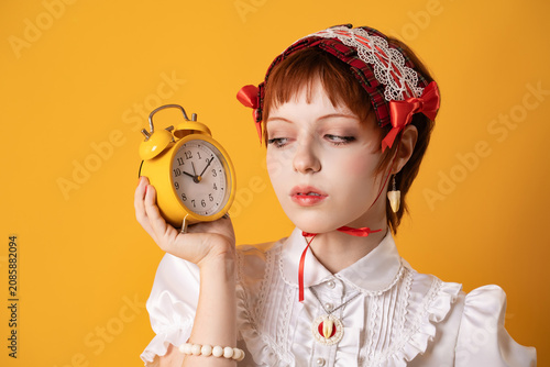 Fotografie A young girl in a studio on a yellow background