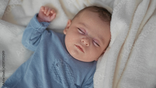 Cuadro en lienzo Baby sleeping on plush blanket with arm raised and fist gently clenched in studio; serenity comfort bonding