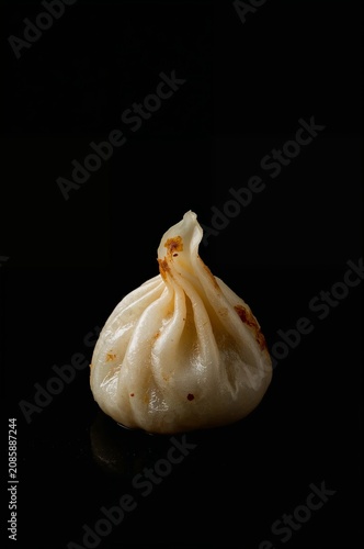 Dumpling Placed on a Dark Surface With a Simple Design and Light Shadows in a...