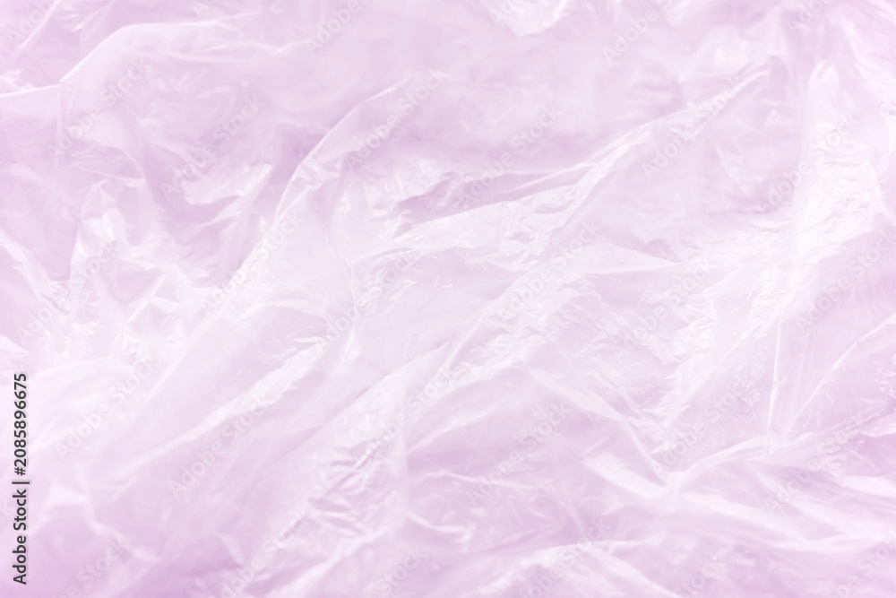 Fototapeta premium Crumpled wrinkled pink plastic bag texture background. Reuse recycle concept.