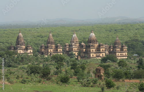 Εκτύπωση καμβά Panoramic view of multiple historic stone chhatris and cenotaphs lined up amidst