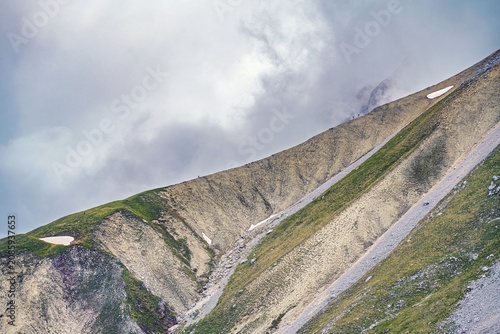 Hiking path in the Wetterstein Mountains near the Hochwanner, scenic alpine landscape with limestone slopes and dramatic clouds in the German-Austrian Alps.