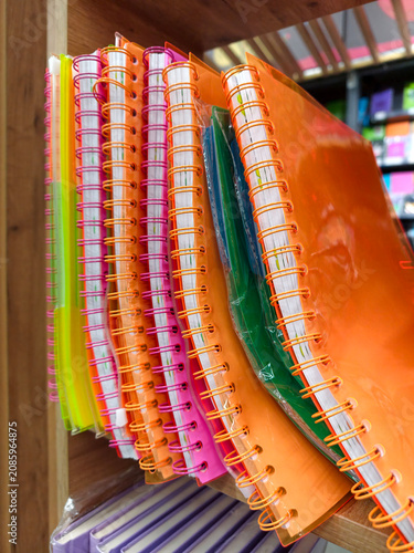 Softcover notebooks with spiral binding displayed in multiple colors on stationery shelf